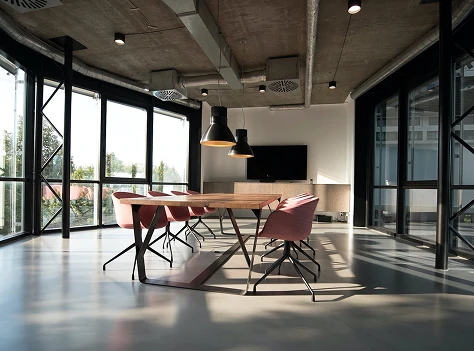 Contemporary office boardroom with large wooden table and modern lighting